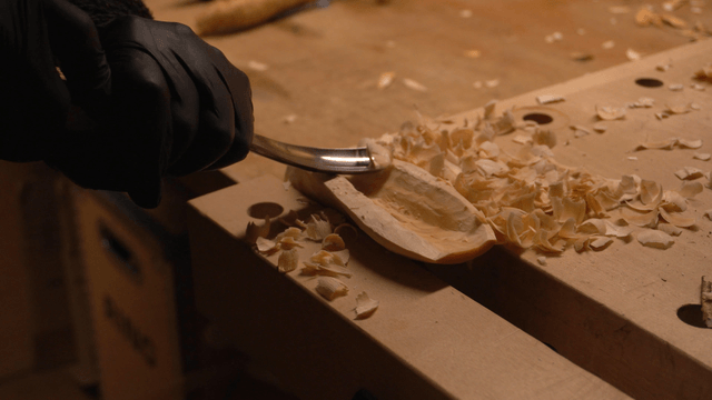 Woodcraft artisan carving wood with a chisel in workshop