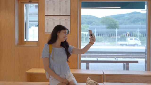 A woman taking a selfie at a train station