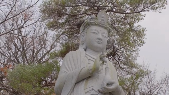 Quiet Buddha statue in a snowy forest