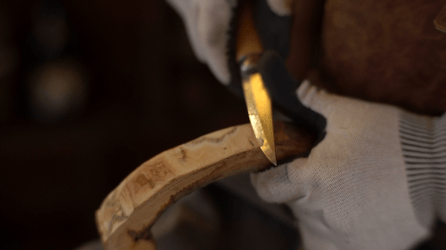 Woodcraft artisan carving wood precisely with a knife