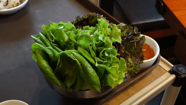 Fresh lettuce and assorted greens with sauce on a tray