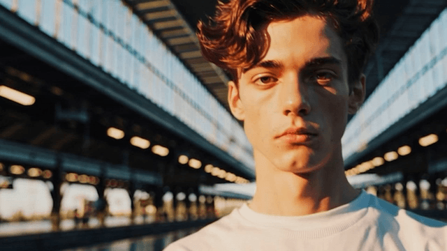 A young man standing at a train station