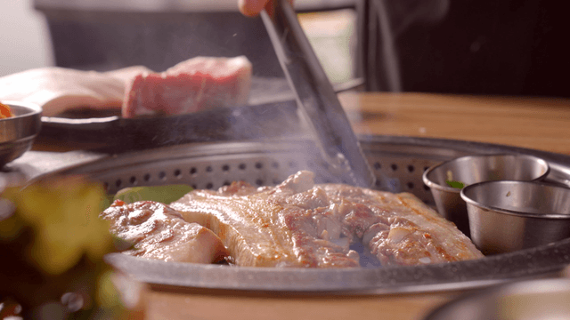 Grilling pork belly on a tabletop grill