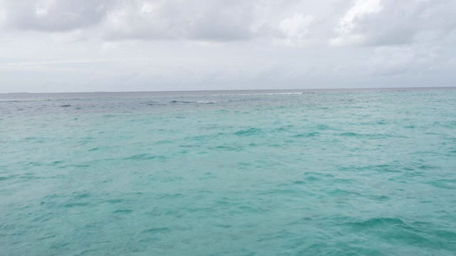 Calm ocean waves under a cloudy sky