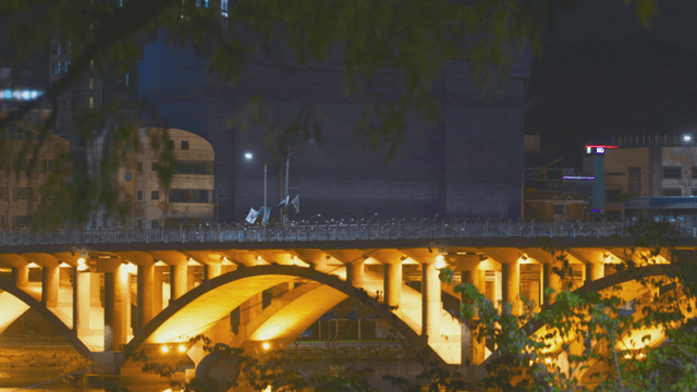 밤에 번화한 도시의 조명이 켜진 다리