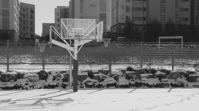 Snow-covered basketball court in the city