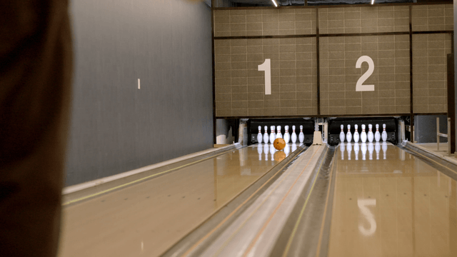 Bowling ball rolling towards pins