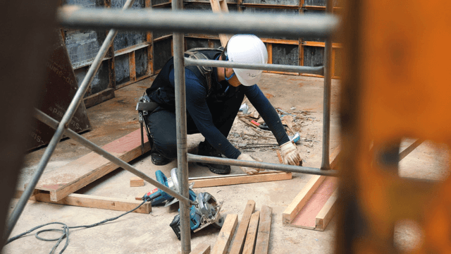 Worker measuring wood at a construction site