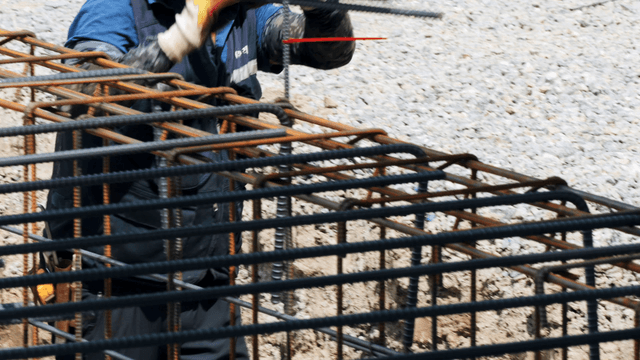 Construction worker handling steel bars