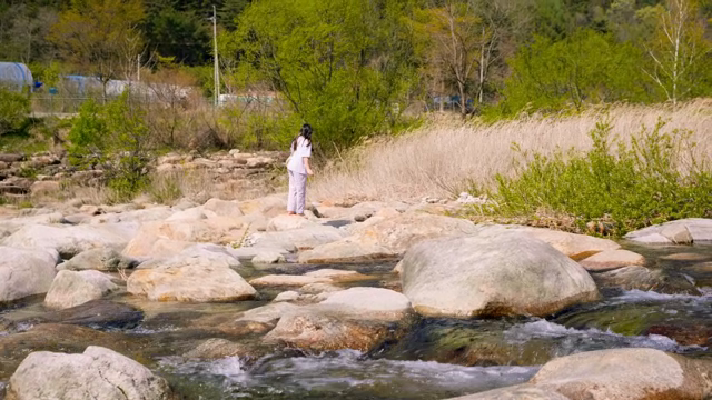 A child exploring a rocky riverbank