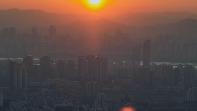 Sunset over a city skyline with mountains