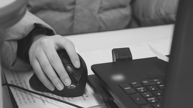 Person using a mouse with a laptop