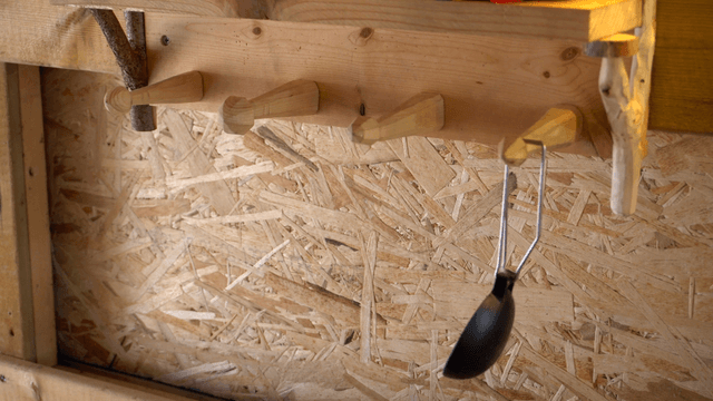 Various tools hanging on a wooden shelf