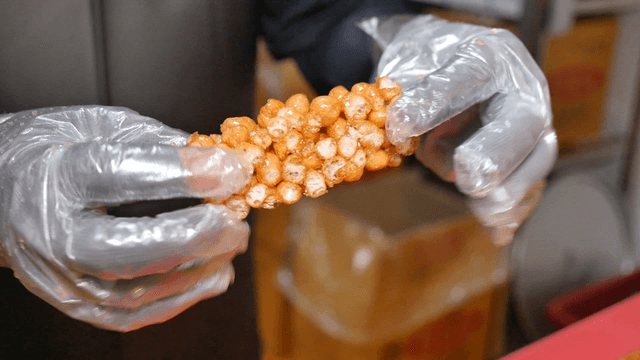 Gloved hands holding Korean oranda snack