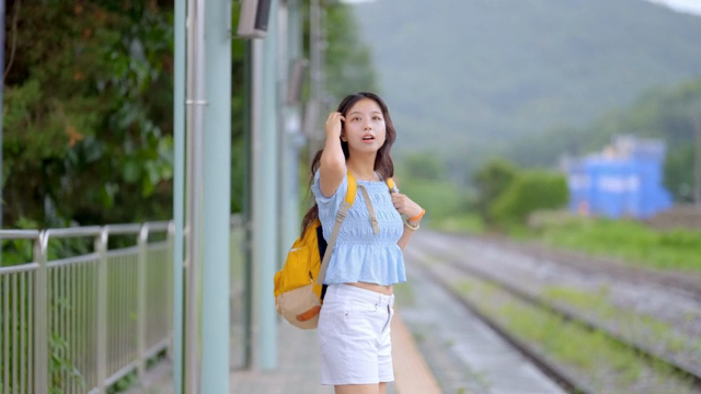 기차역에서 기다리는 젊은 여성