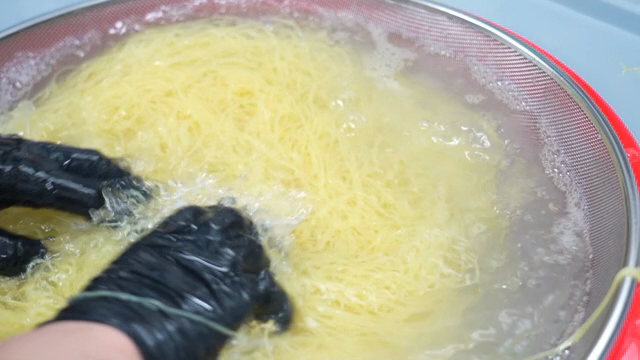 Rinsing cooked noodles in a strainer