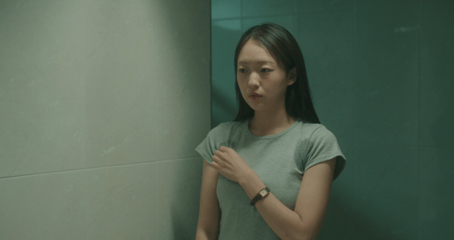 Sweaty woman looking in a bathroom mirror