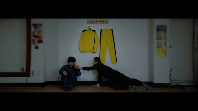 Man stopping a young man making a serious phone call in a martial arts dojo