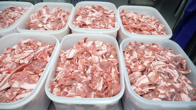 Containers filled with raw meat in a kitchen