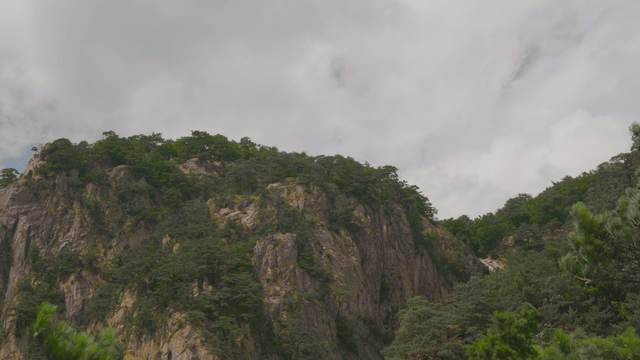 Blue rocky mountain under cloudy sky