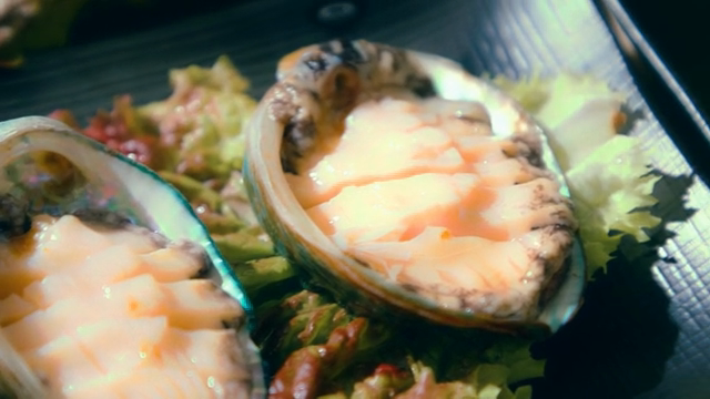 Freshly sliced abalone on a bed of lettuce