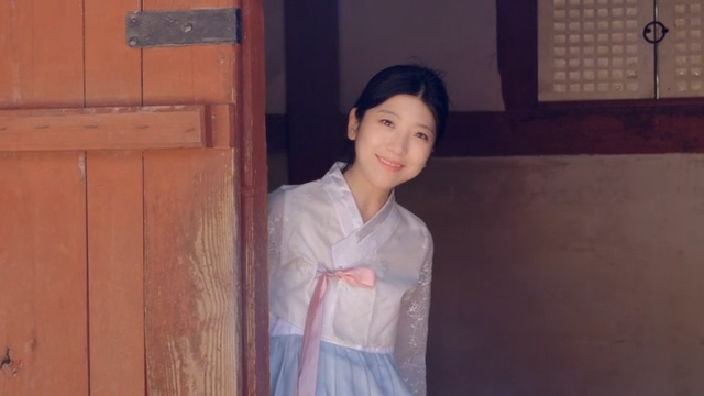 문에서 미소 짓고 있는 한복 입은 여성