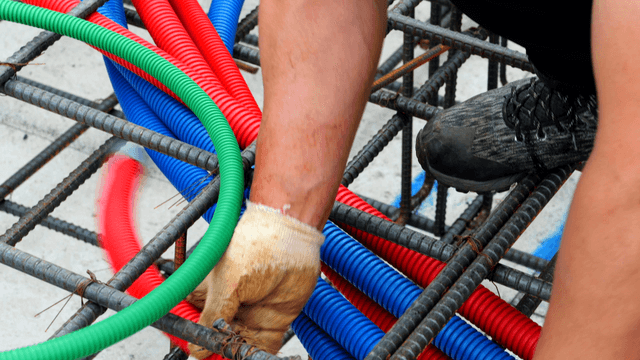 Worker assembling colorful cables on site