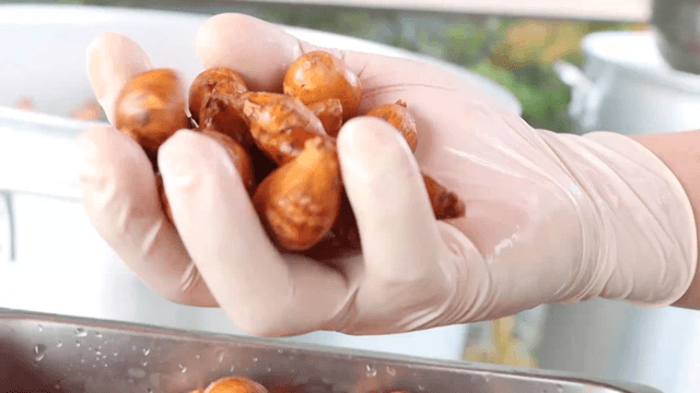 A handful of sunchokes taken from a metal container