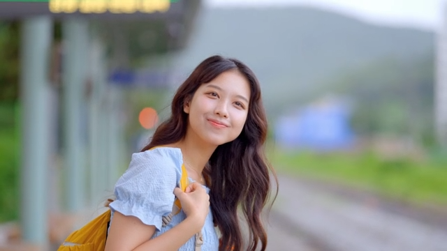 기차역에서 미소 짓는 젊은 여성