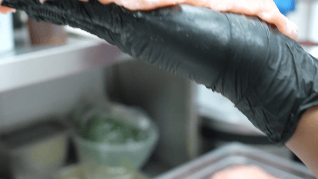 Raw pork held in a gloved hand