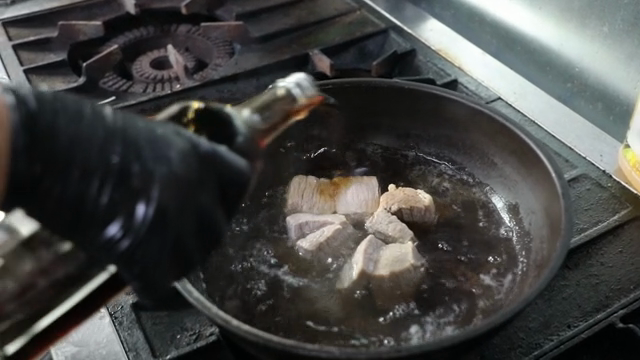 Cooking pork in a pan with sauce