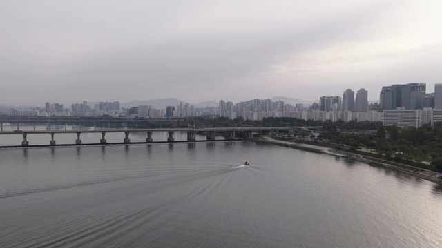 Boat cruising on a river with city skyline