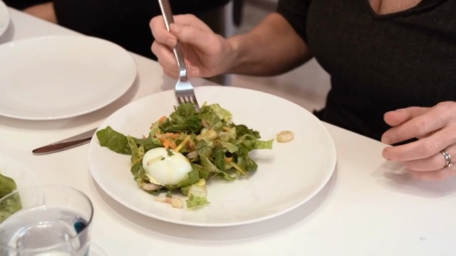A person enjoying a fresh salad indoors