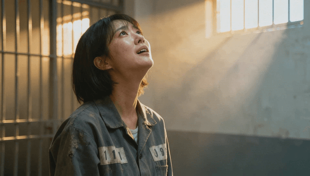Female prisoner looking upward in cell