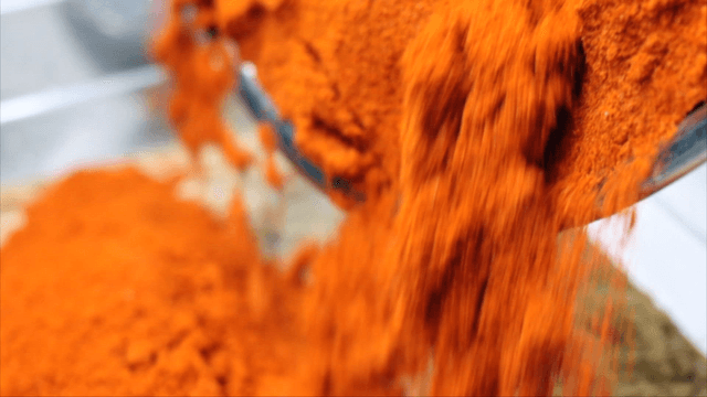 Red chili powder poured into container