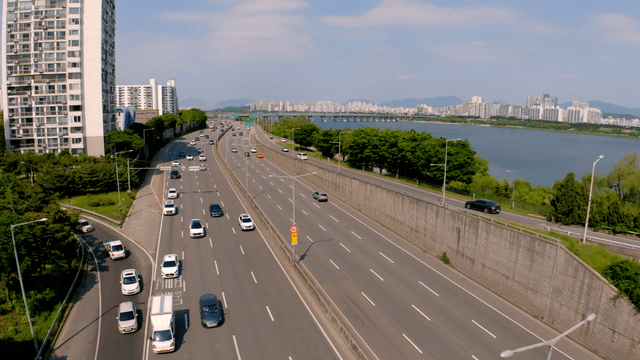 Busy highway beside river and cityscape