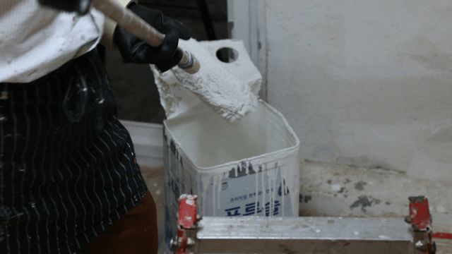 Person dipping a roller in paint