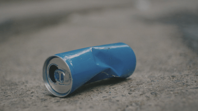 Crushed blue can on the pavement
