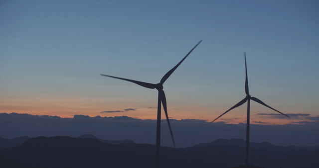 산 너머 일몰의 풍력 터빈