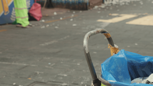 Street cleaner tidying up a busy sidewalk