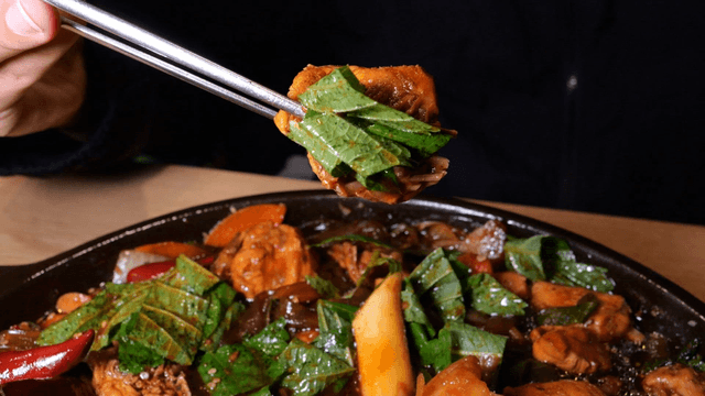 Chopsticks holding perilla leaf braised chicken