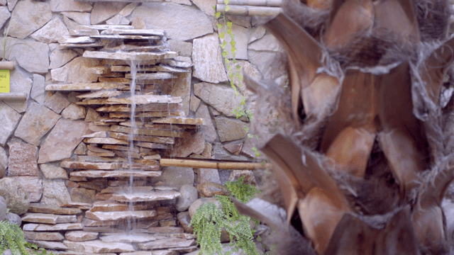 A small artificial waterfall on a stone wall