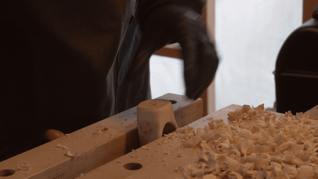 Wooden scoop head being drilled in a cozy workshop