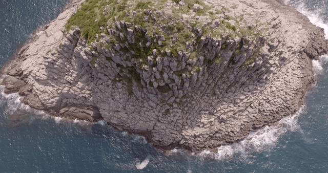 Rocky cliff by the ocean with waves
