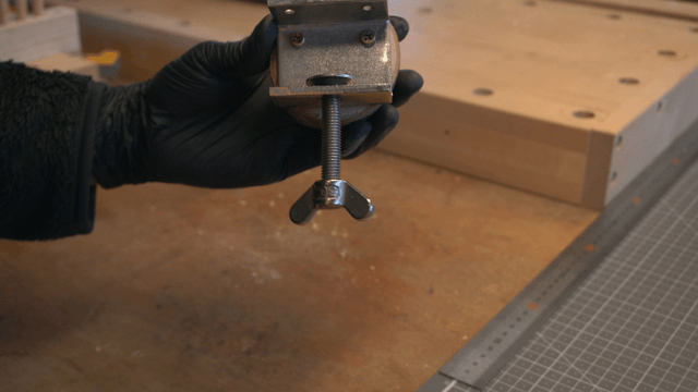 Hand holding a bracket attached to a wooden block