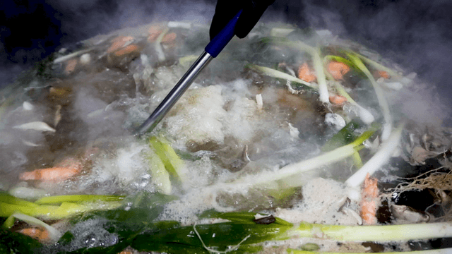 Deep seafood broth simmering with vegetables