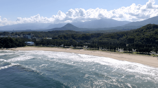 Serene beach with waves and mountains