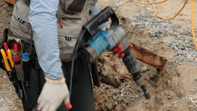 Worker using a drill at a construction site