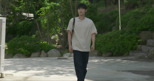 Young man walking outdoors with a camera
