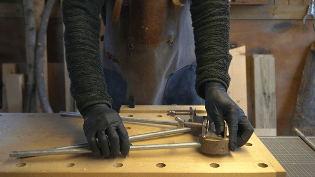 Craftsman assembling metal rods on workbench
